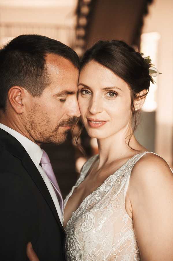 bride looks into camera and groom touches his forehead to bride's face