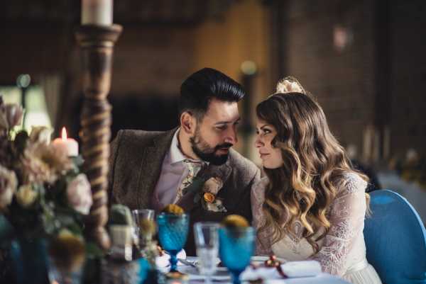 bride and groom exchange private words seated at the bridal table