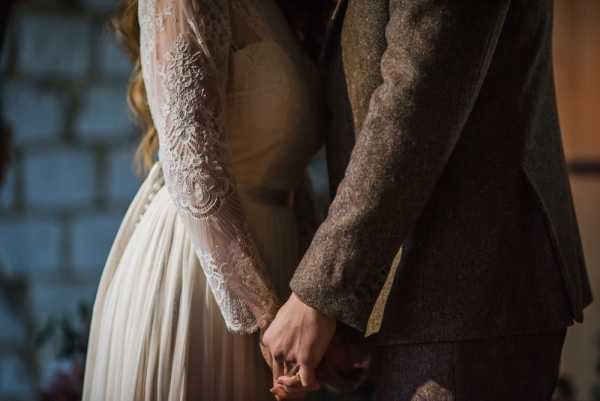 bride and grooms hands holding each other