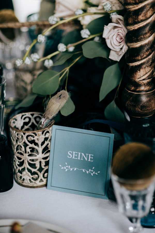 green table name wedding stationery surrounded by green foliage that reads "Seine"