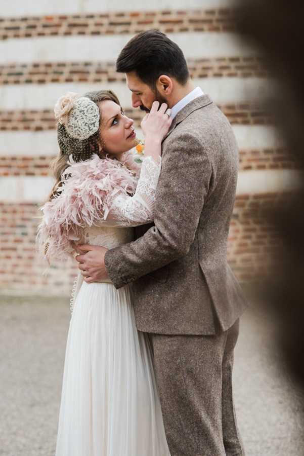 bride and groom kiss in 1920s inspired wedding outfits