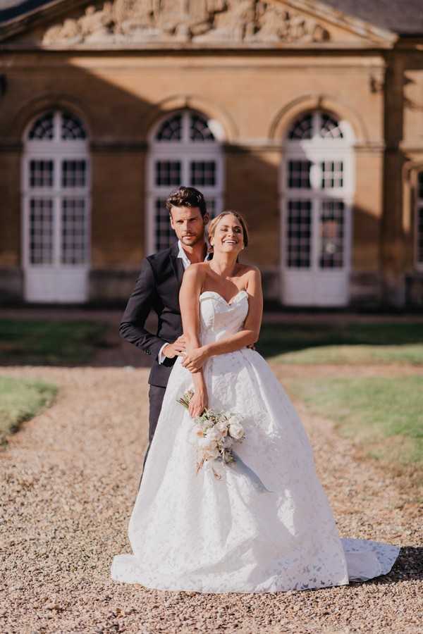 Bride and groom stand outside Chateau Cons La Grandville