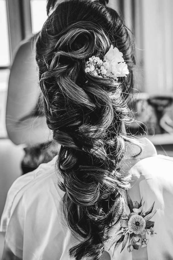 black and white image of brides completed hair style with white flowers