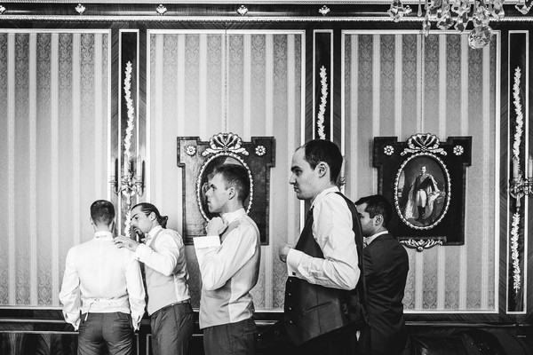 groom and groomsmen getting ready in black and white