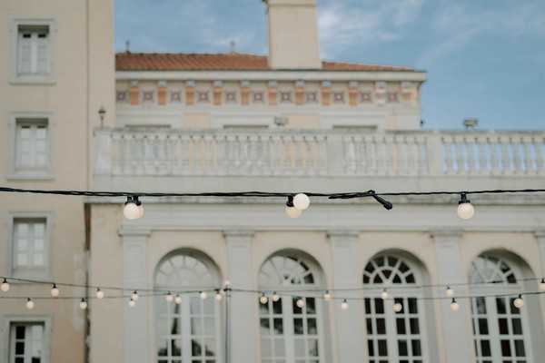 image of building with arch windows and festoon lighting in the foreground