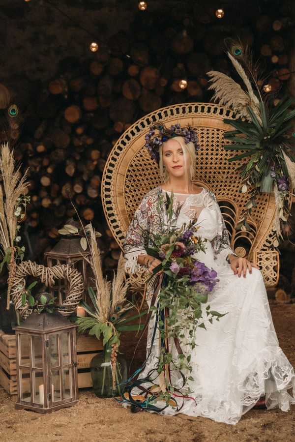 bohemian bride on rattan peacock chairs wearing peacock feather crown