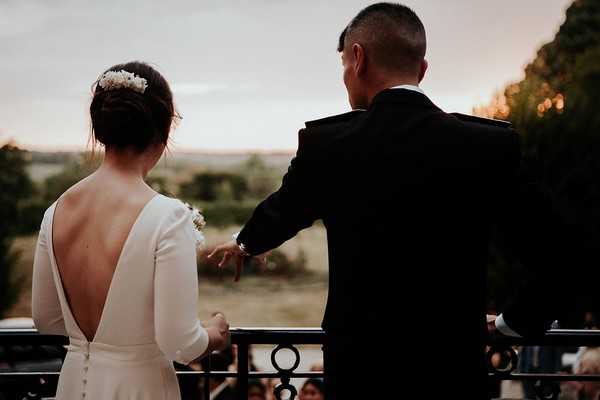 bride and groom overlook the grounds of chateau santeny on the balcony