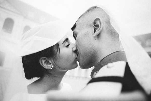 bride and groom kiss under bride's veil