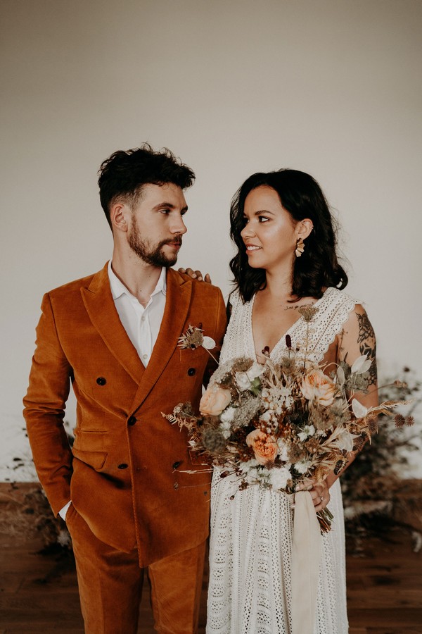 A modern blending of cultures between this couple in orange suit and lace dress