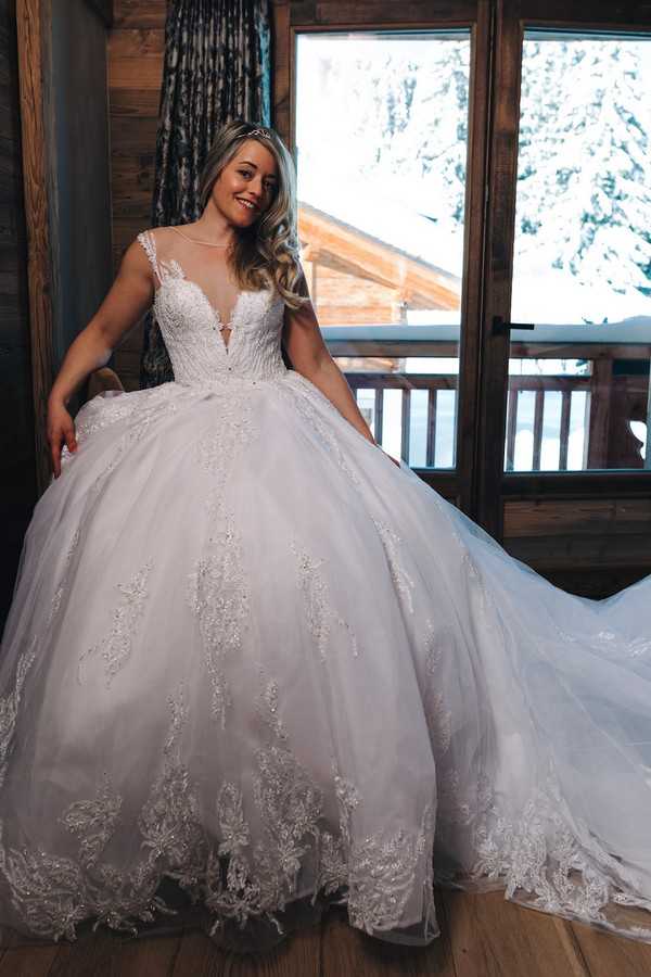 bride poses in white large skirted wedding gown with crystal beading 