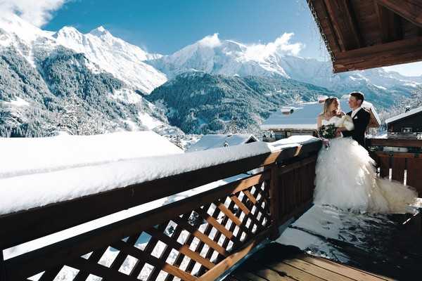 bride and groom on snowy balcony of french alps private chalet