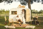Ema & Hyppolite In "A Boho Wedding In Camargue" Feature Image of bride and groom in small campervan that has been set up as a photobooth