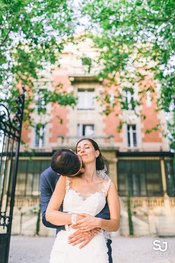 Newly weds hug in front of the facade of Chateau la Beaumetane