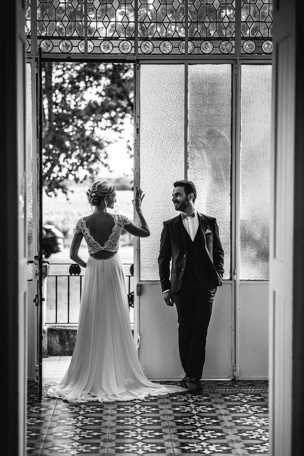 Black and white image of couple standing in the doorway of a French Chateau