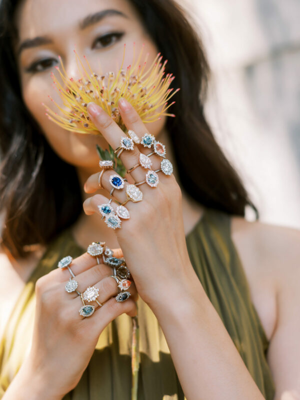 Girl holding flower wearing multiple rings on each of her fingers