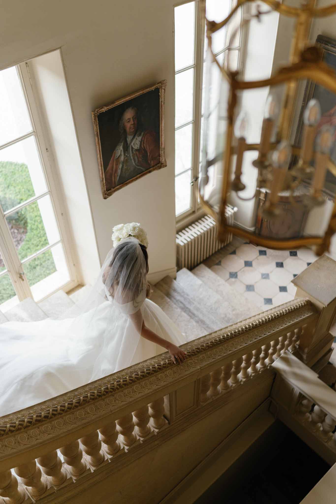 Bride in ivory dress on elegant staircase in neoclassical interior venue