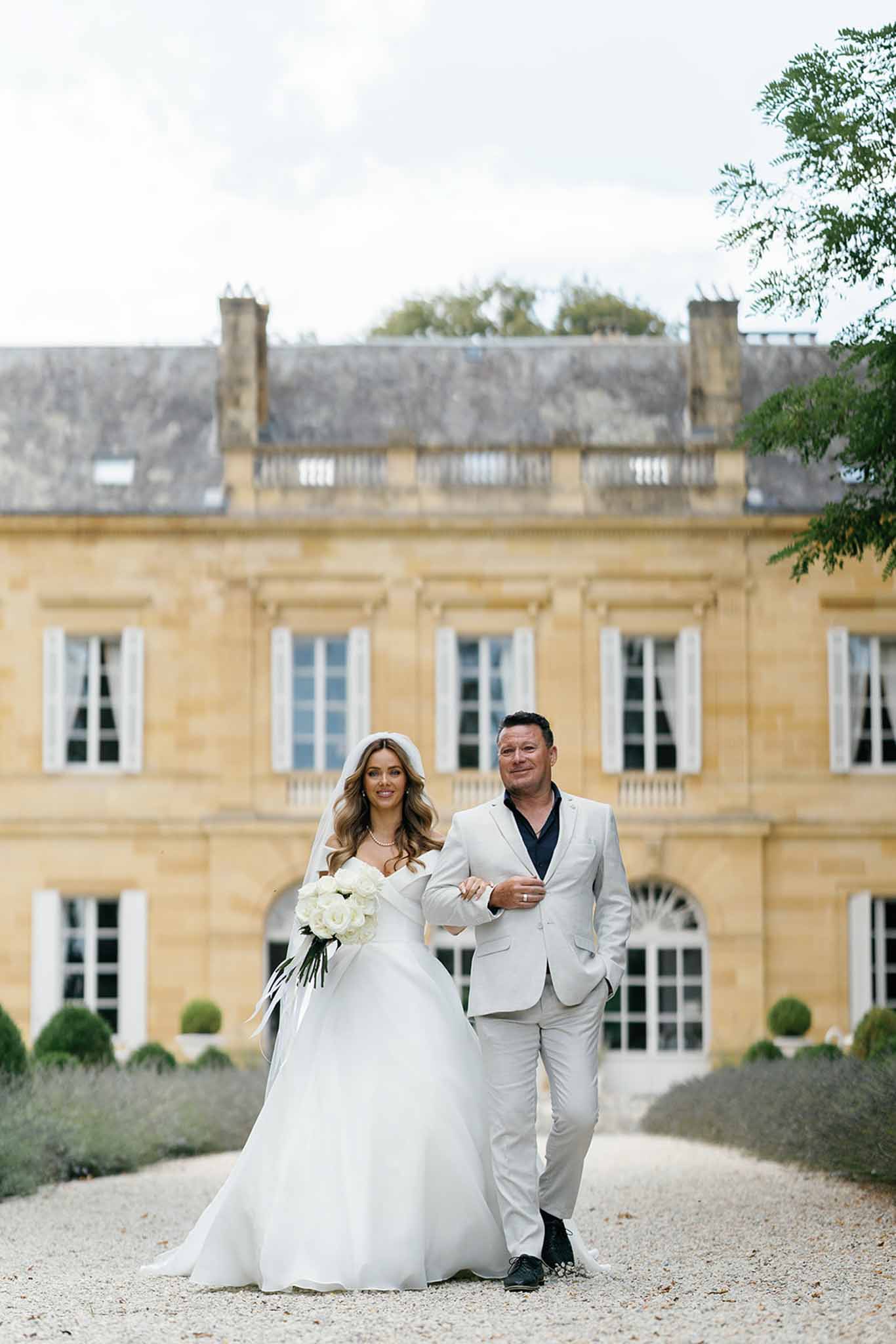 Bride and groom formal portrait in front of neoclassical chÃƒÂ¢teau courtyard