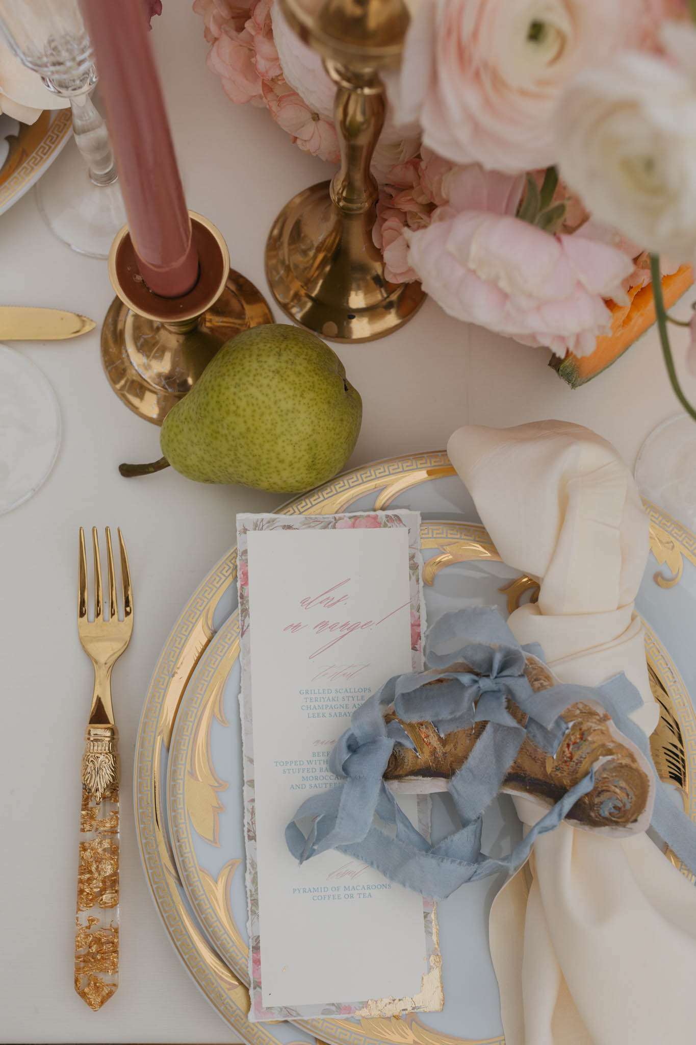 Place setting with gold charger dusty blue plate pink calligraphy menu blush peonies and gold flatware