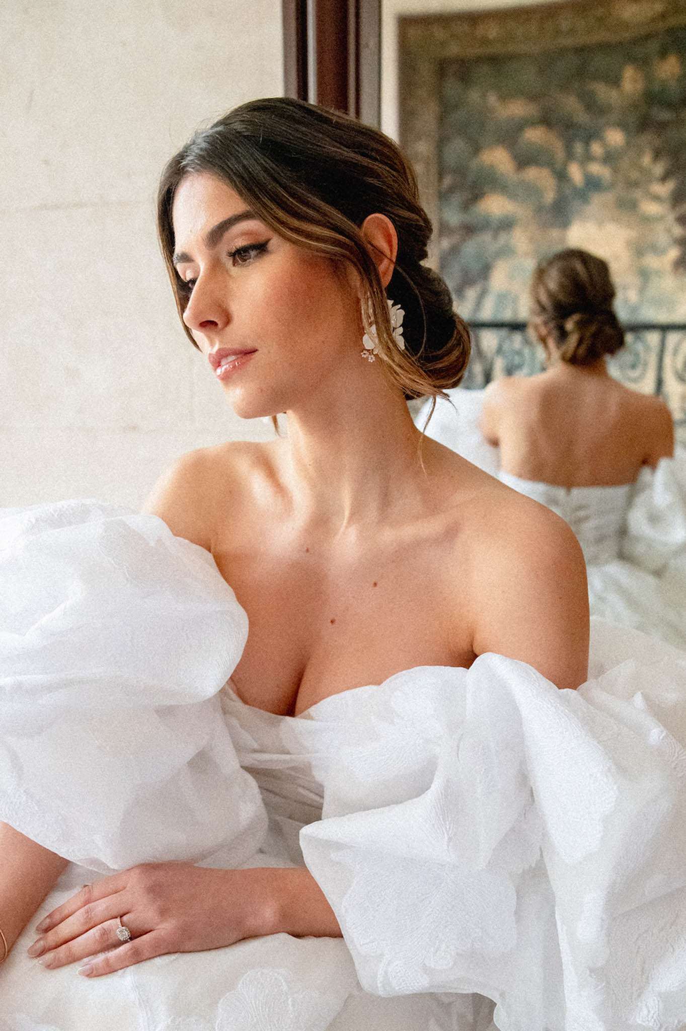 Bride in off-shoulder organza puff-sleeve gown with mirror reflection showing open back