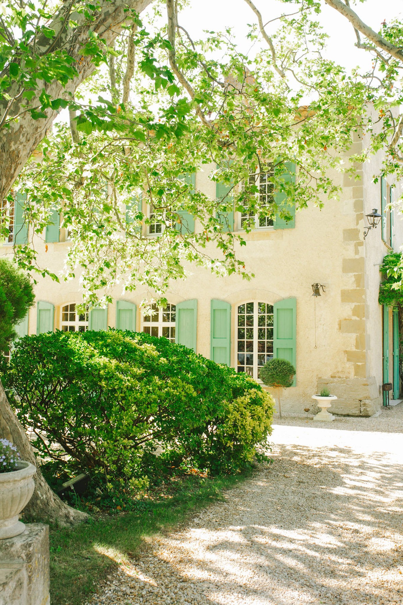 Bride in ivory gown with floral headpiece walking in garden at Domaine de Lamanon