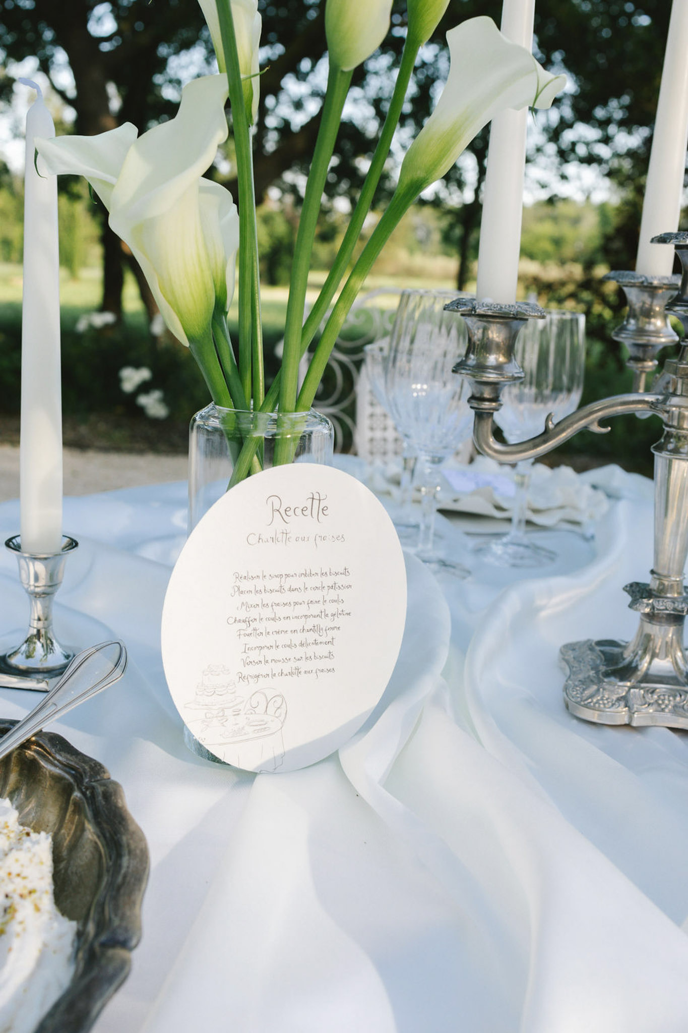 Hand-calligraphed French menu card at an outdoor reception table