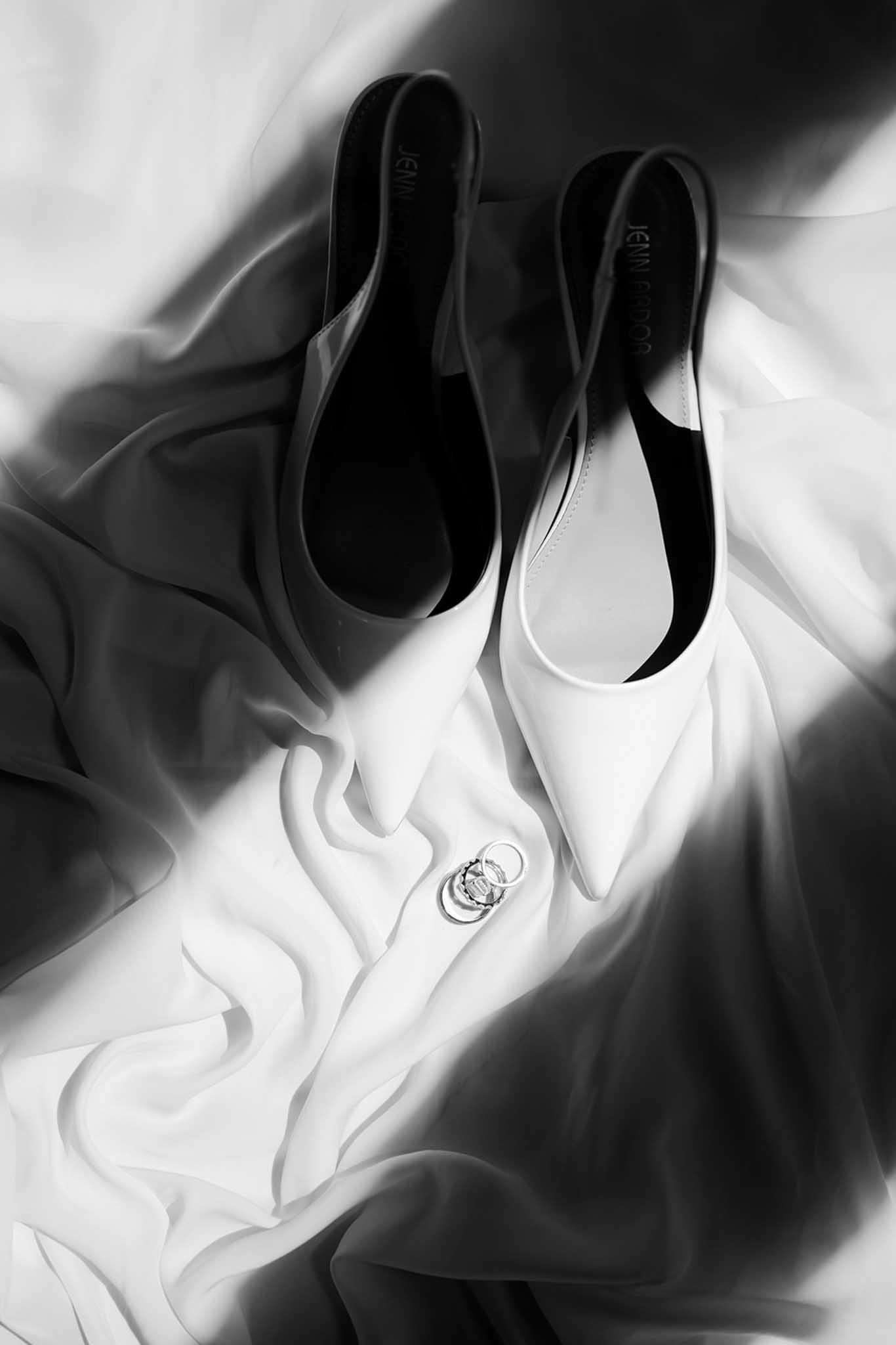 Flat lay of bridal shoes, accessories, and invitation details