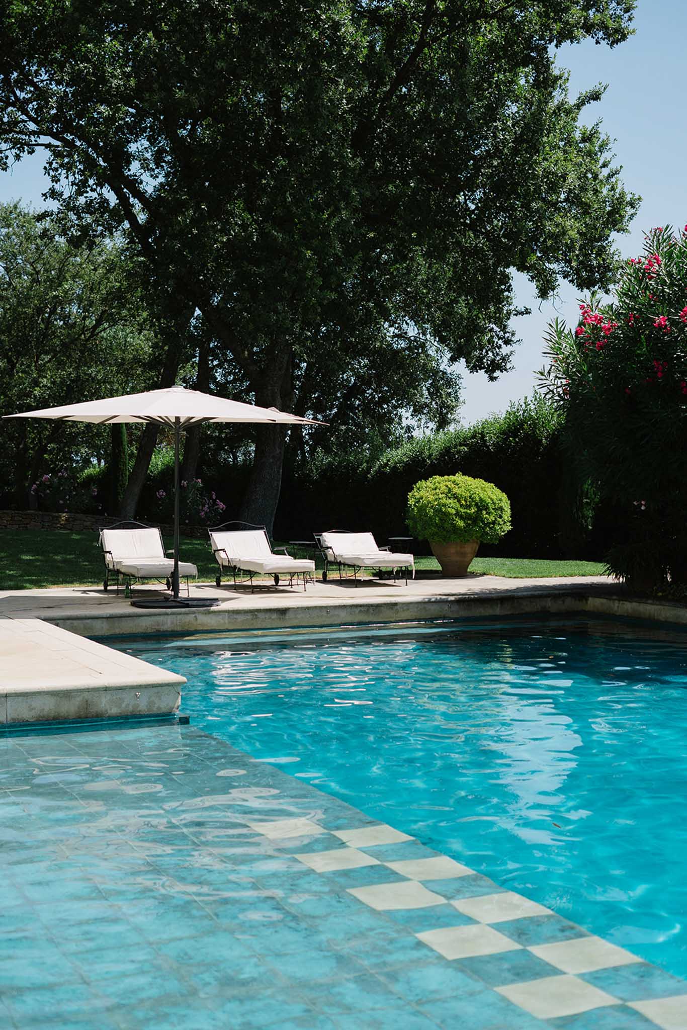 Swimming pool with loungers and olive trees at Mediterranean venue setting