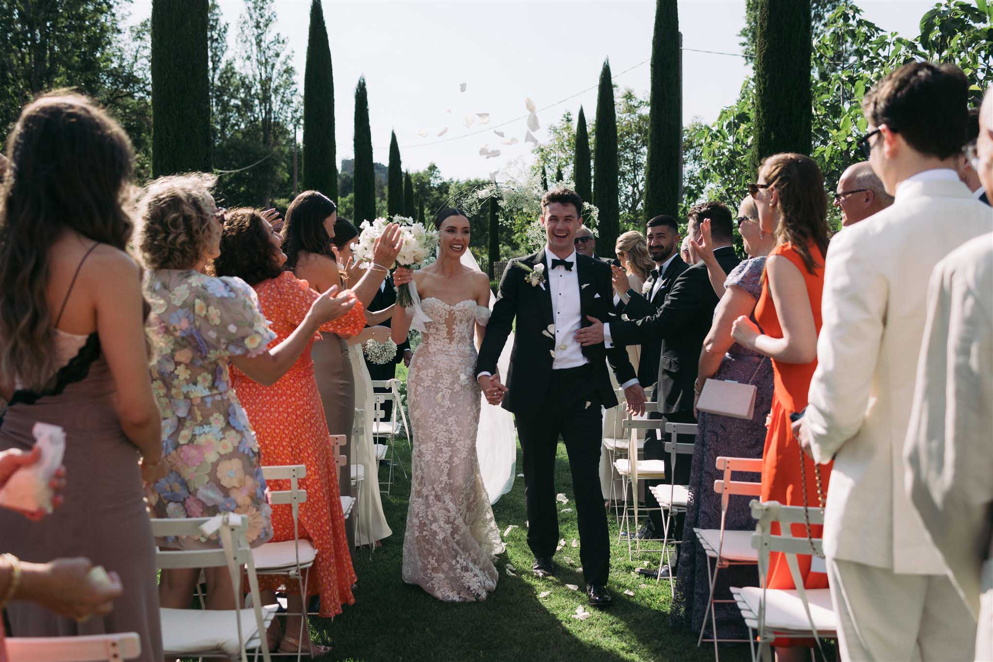Bride and groom during a confetti exit in a garden setting