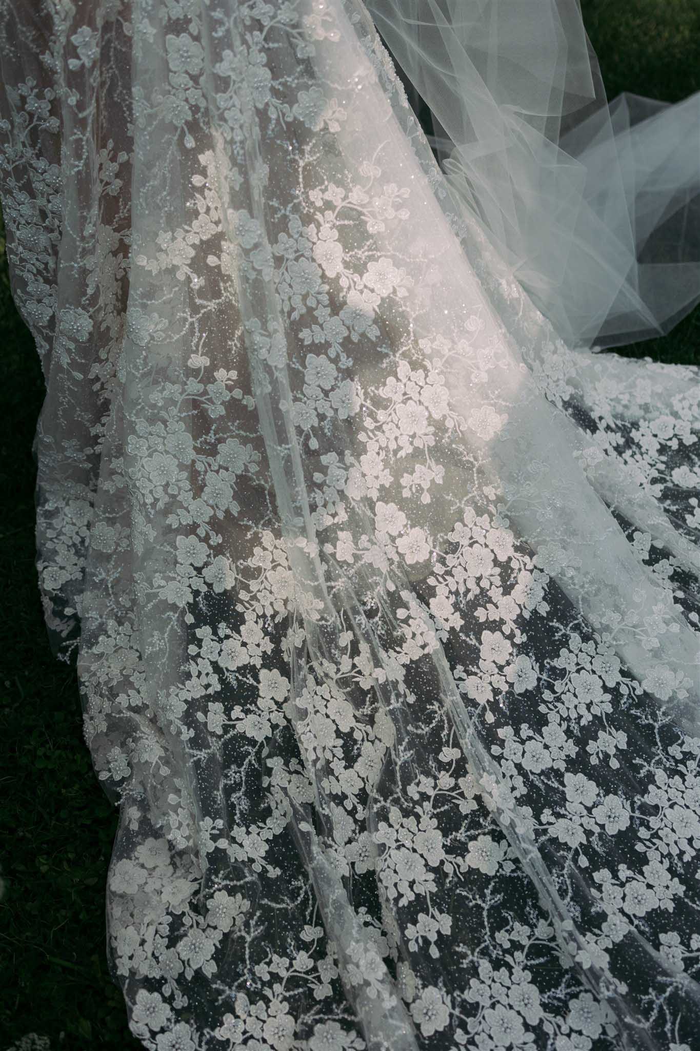Close-up detail of lace wedding dress train at Abbaye Saint-Eusebe photographed by Ayata