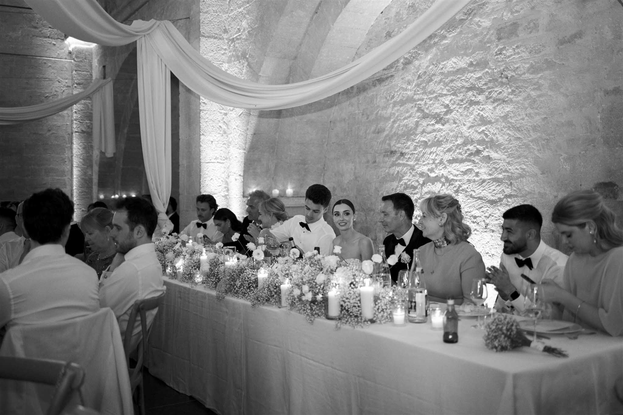Long reception table at Abbaye Saint-EusÃ¨be with bride and groom, black and white photograph