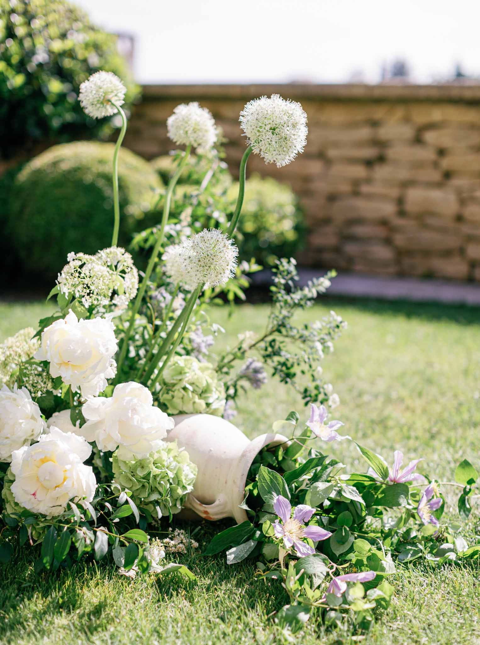 Close-up of ceremony floral arrangement with cream roses, white allium, and lavender