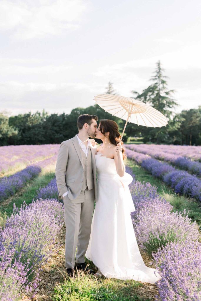 Lavander Fields A.Lucas bride holding umbrella while kissing groom