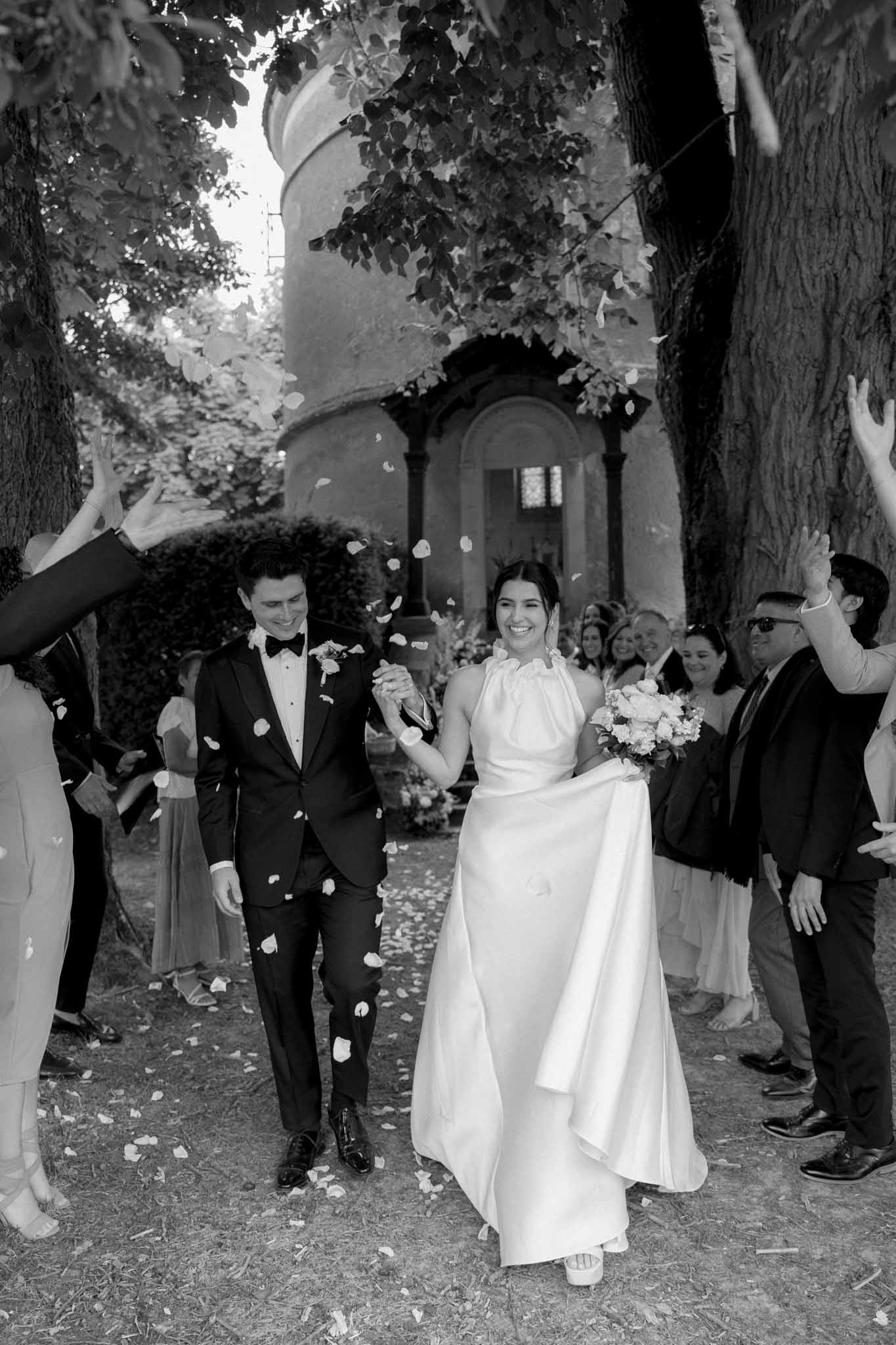 Black and white bride and groom walking together in a garden setting