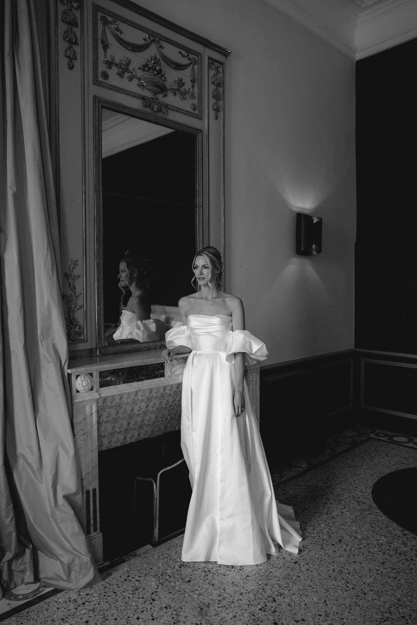 Black-and-white bridal portrait before ornate neoclassical mirror in classical interior