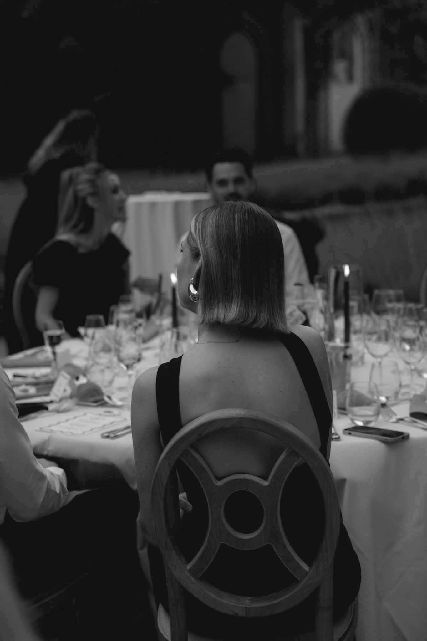 Close-up detail shot of back of guest's black and white outfit at ChÃ¢teau de Martinay wedding