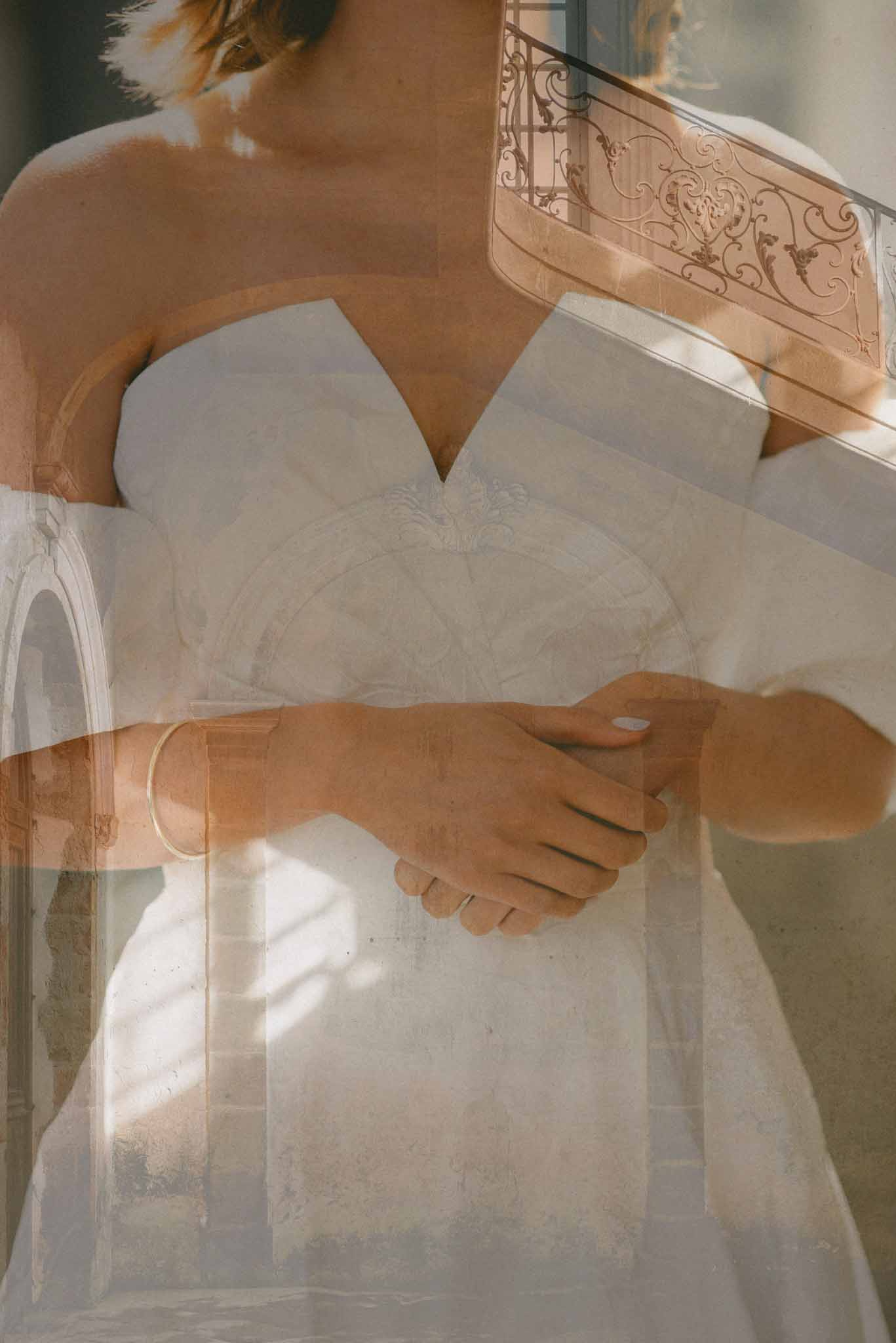 Double-exposure portrait of bride in strapless gown overlaid with chateau ironwork and stone arches