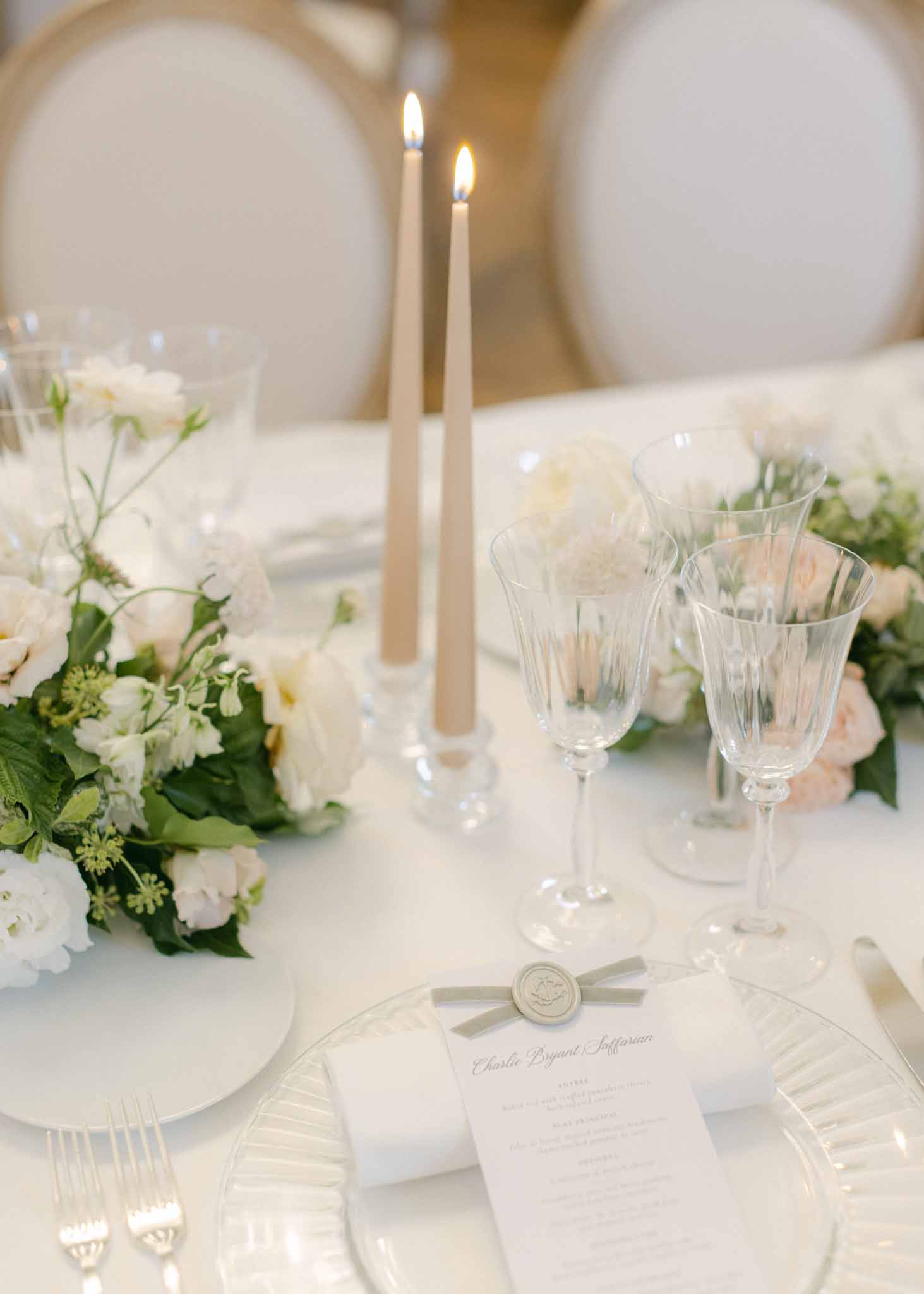 Reception table setting with ivory linens and crystal glassware