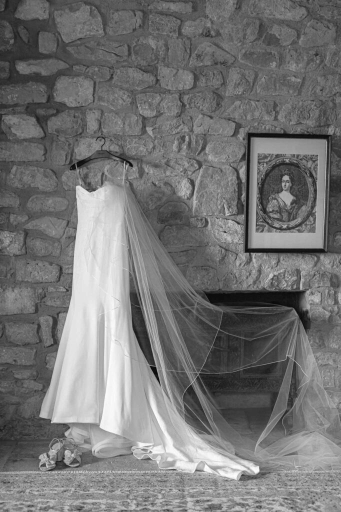 Chateau Cassis Olya bride dress hanging brick wall painting black white photo