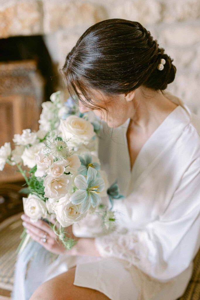 Chateau Cassis Olya bride sitting holding smelling bouquet