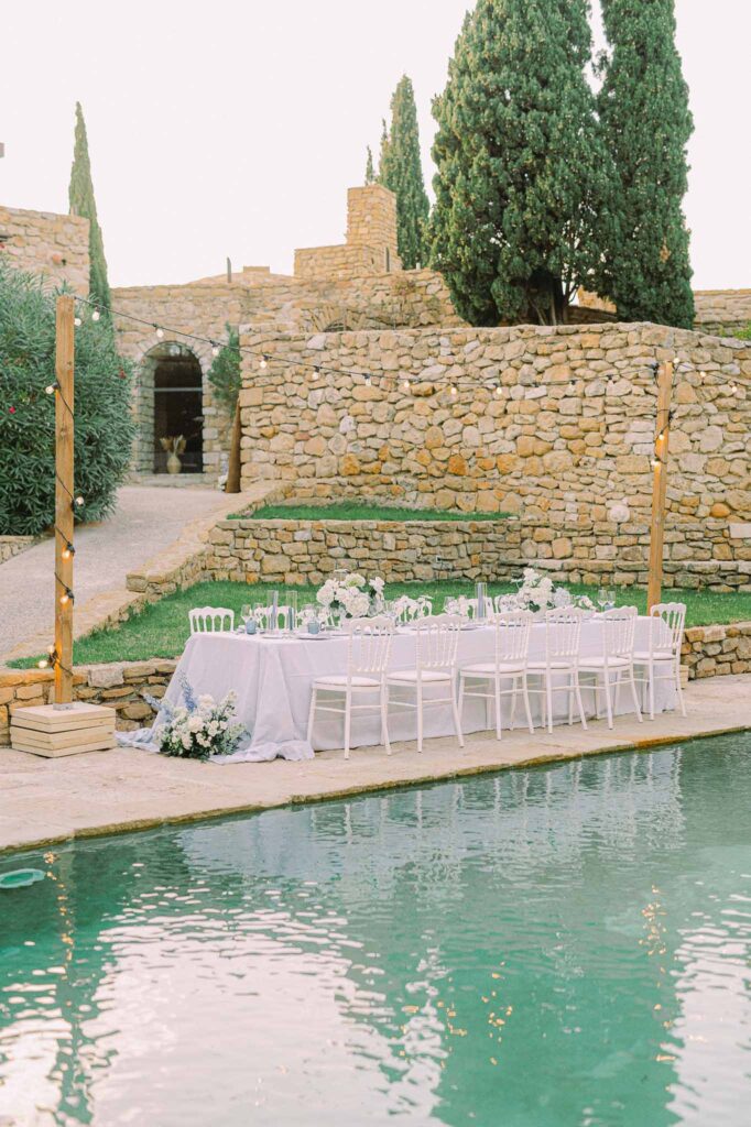 Chateau Cassis Olya long white presidential reception table beside pool