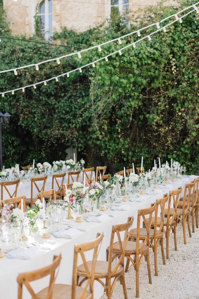 Chateau Robernier N.Elsen detail shot long reception table wood chairs stringlights wedding in provence 