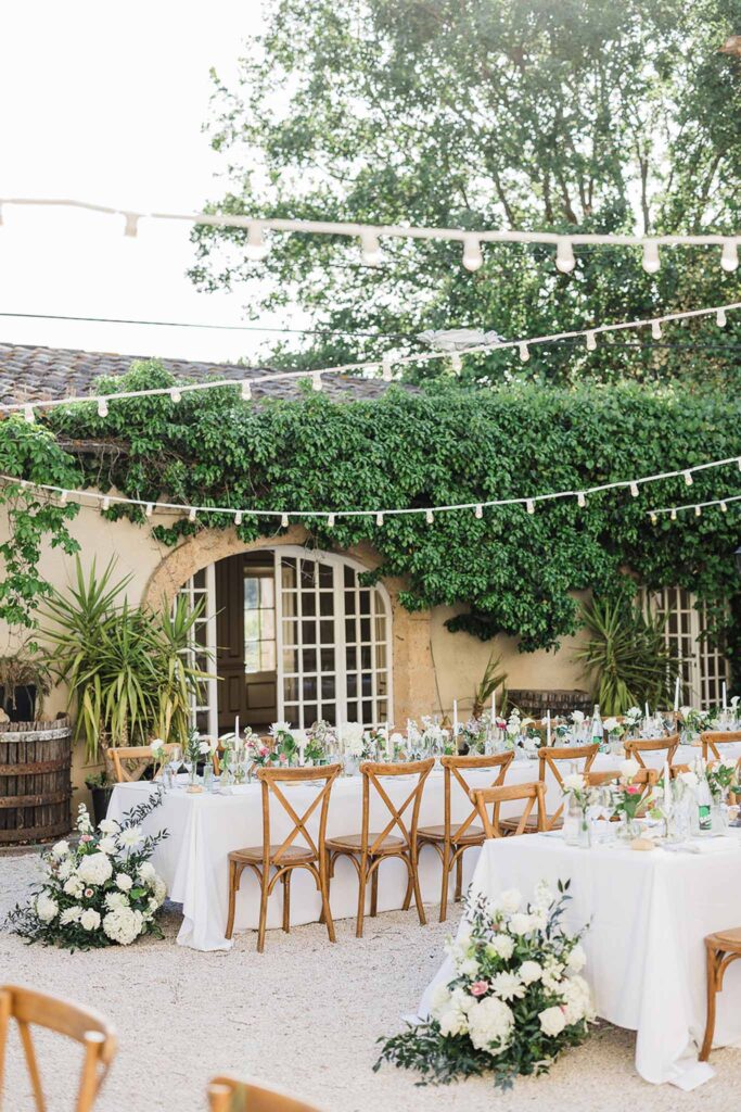 Chateau Robernier N.Elsen detail shot long reception table wood chairs stringlights white flowers