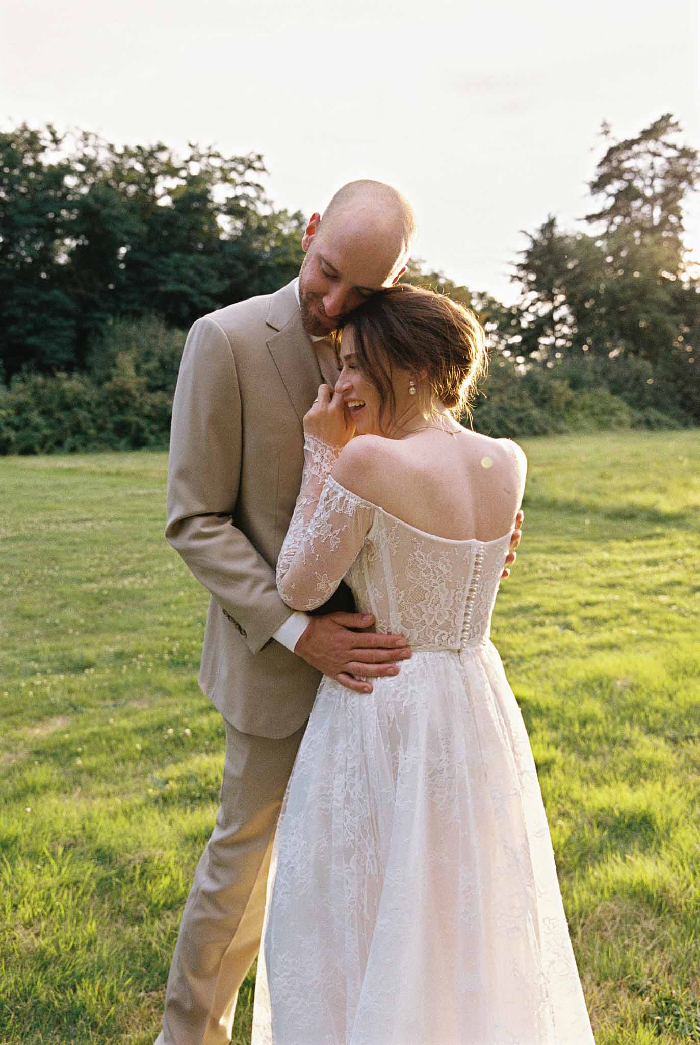 Bride and groom intimate portrait in open field during golden hour