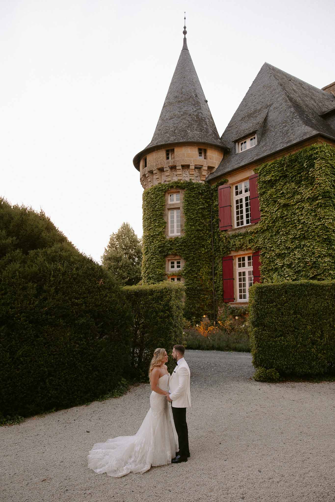 Bride and groom portrait on gravel courtyard pathway at French chÃƒÂ¢teau wedding venue