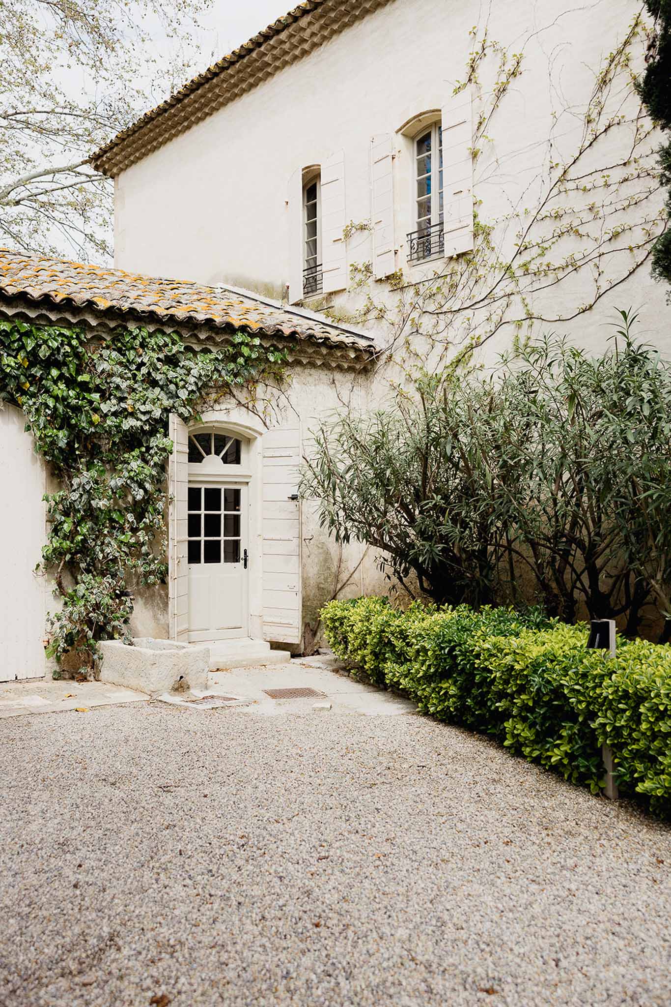 French countryside wedding venue courtyard entrance with cream stone building and terracotta tile roof