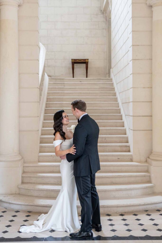 Chateau de Baronville Arielle Barlett bride groom hugging down stairs white