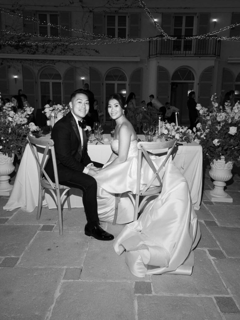 Domaine Mont Leuze CC Weddings bride groom holding hands sitting reception black white photo