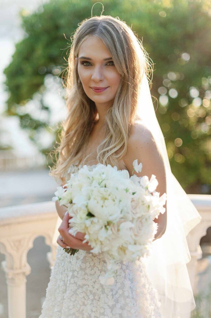 Villa Ehprussi Tatyana bride close up shot blonde wavy hair holding white bouquet sunset
