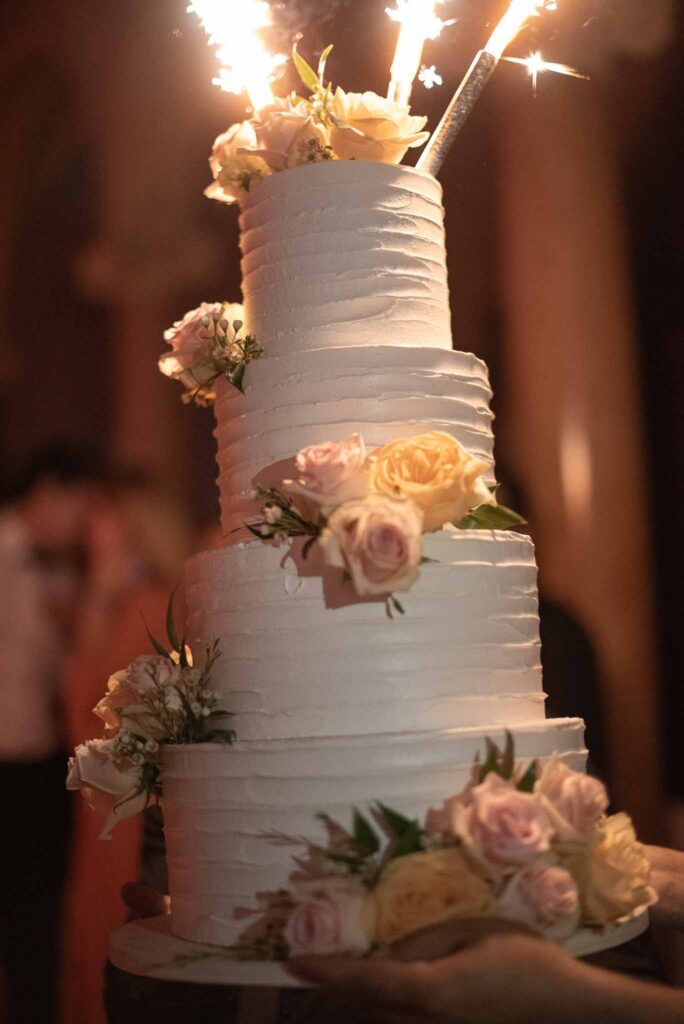 Villa Ehprussi Tatyana detail shot four tier white cake flower decor sparkle candle