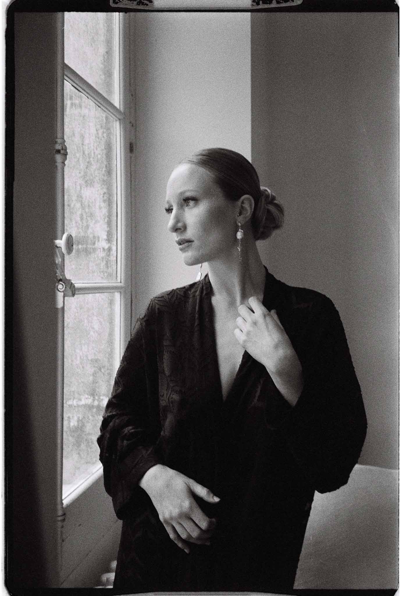 Black and white bridal portrait by window in minimalist indoor setting
